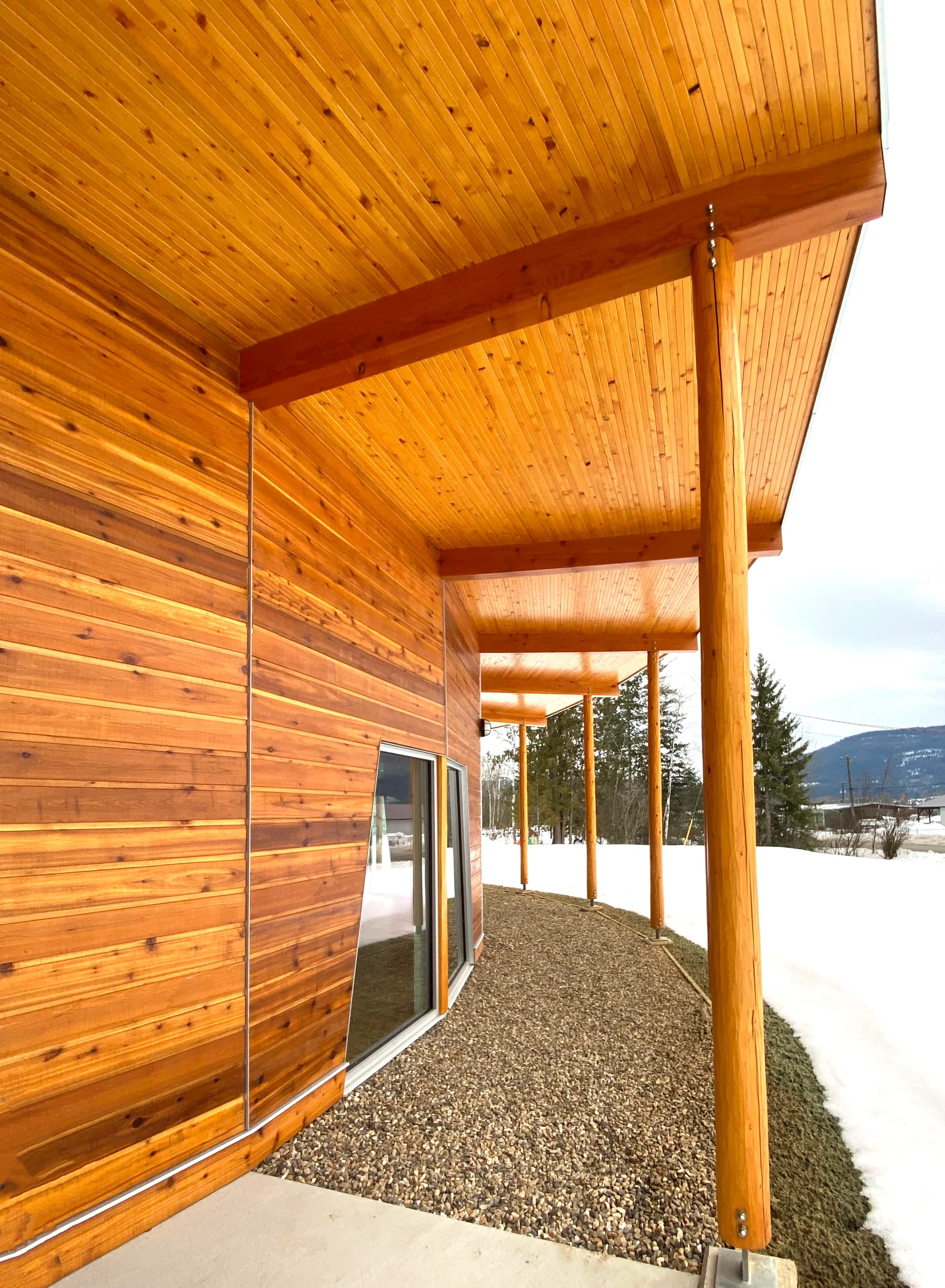 The covered walkway along the cedar-clad elevation, looking out to the valley in winter.